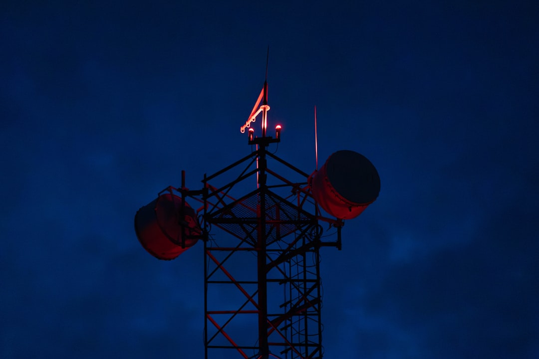 Cell tower with red lights against dark sky