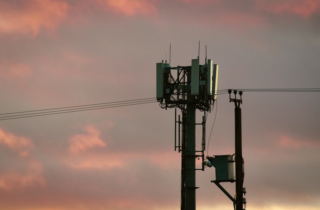 Cell tower against a colorful sunset sky