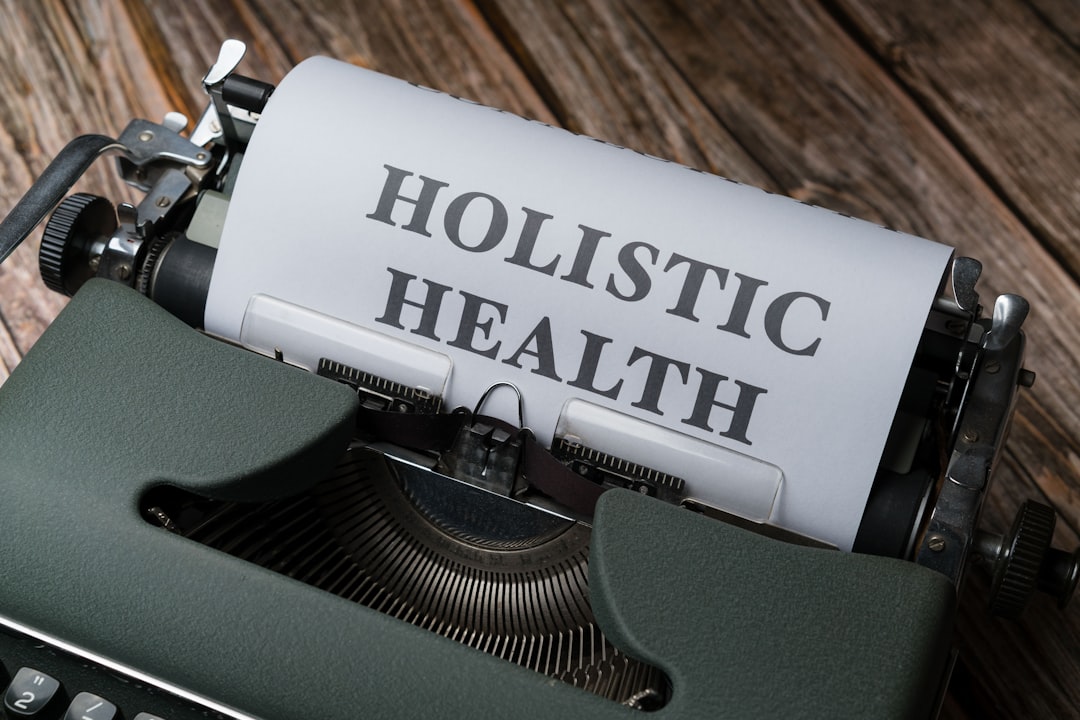 a close up of a typewriter with a paper that says holstic health