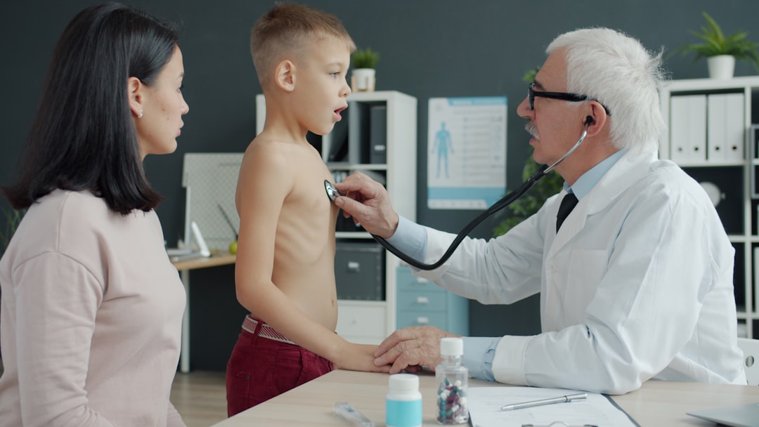 Doctor examines a young boy's chest with stethoscope.