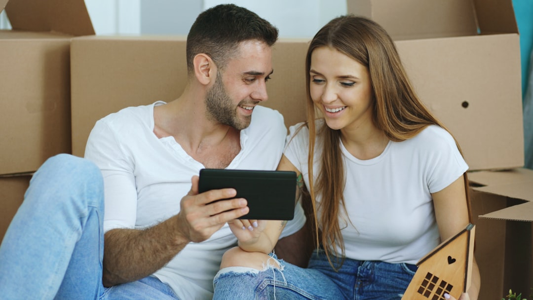 Couple looking at tablet surrounded by moving boxes