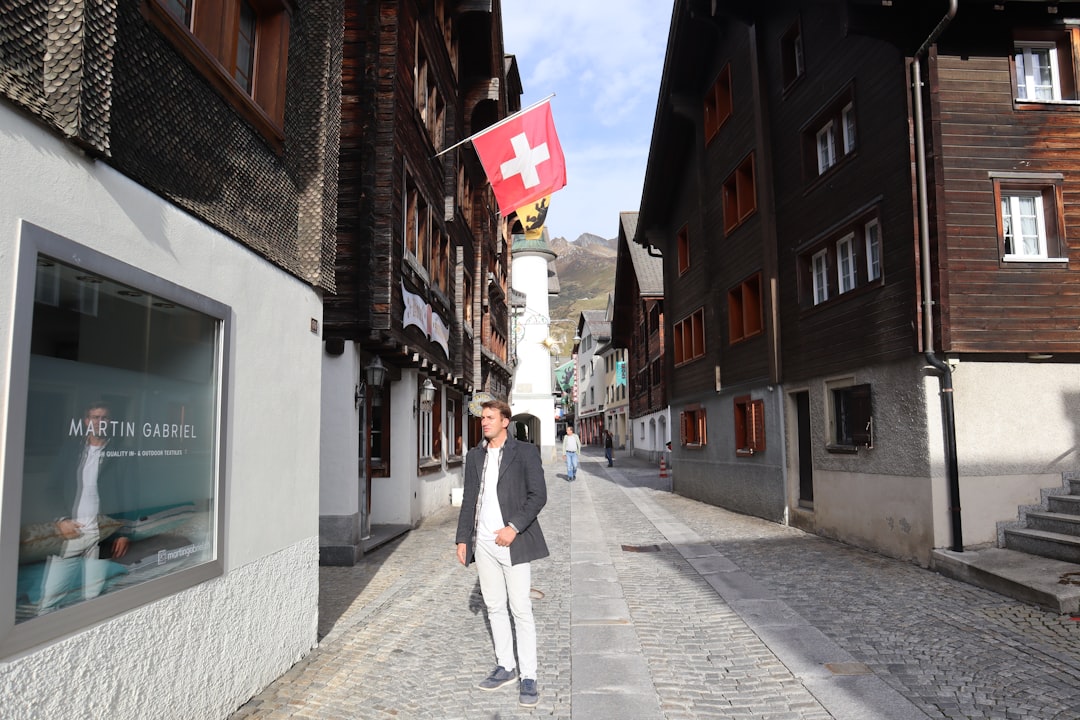 a man walking down a street next to tall buildings