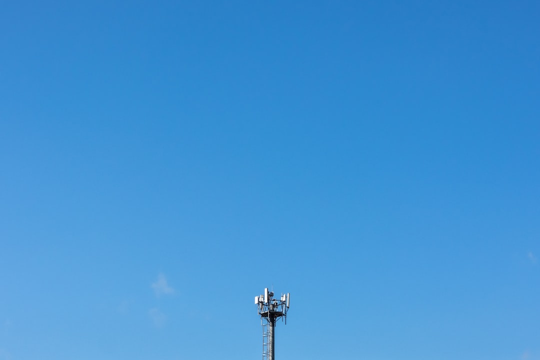 A tall tower with lights against a clear blue sky.